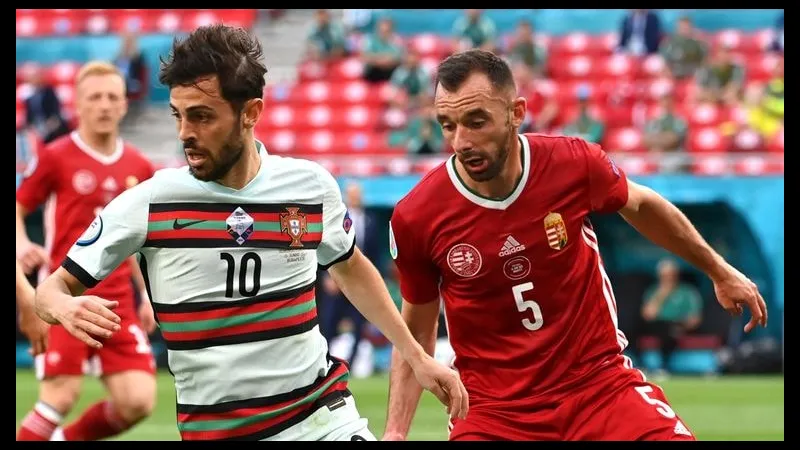 Cầu thủ Bồ Đào Nha với bóng trước sự truy đuổi từ cầu thủ Hungary trong trận đấu